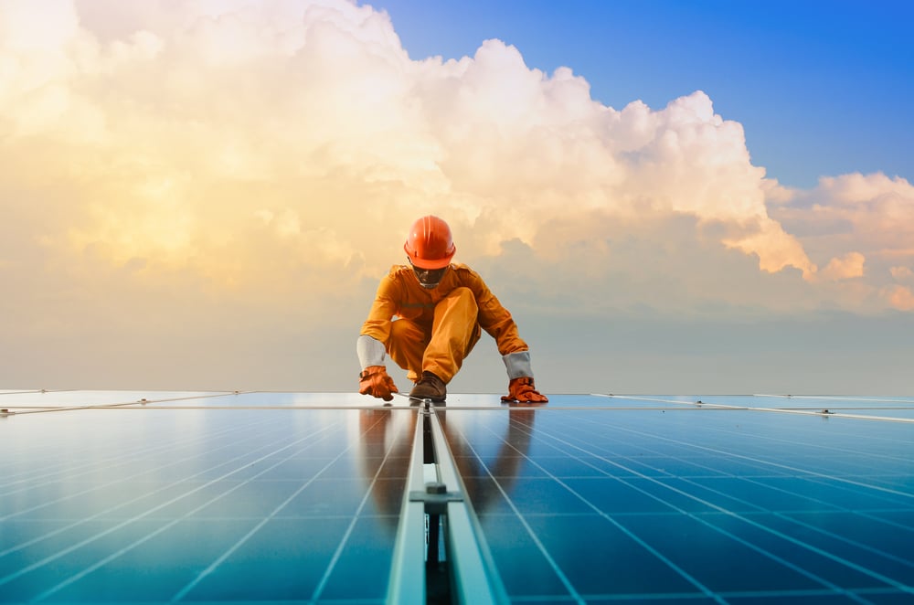 Photo d'un monsieur qui travaille sur des panneaux solaires