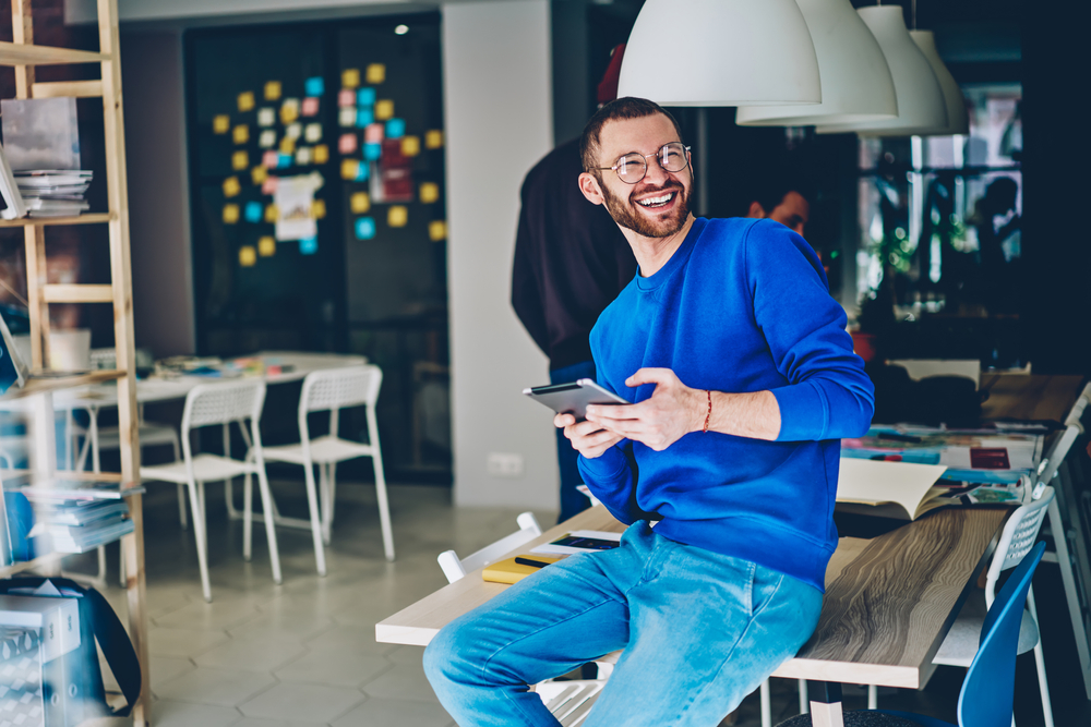 Photo d'un homme entrain de sourire assis sur une table