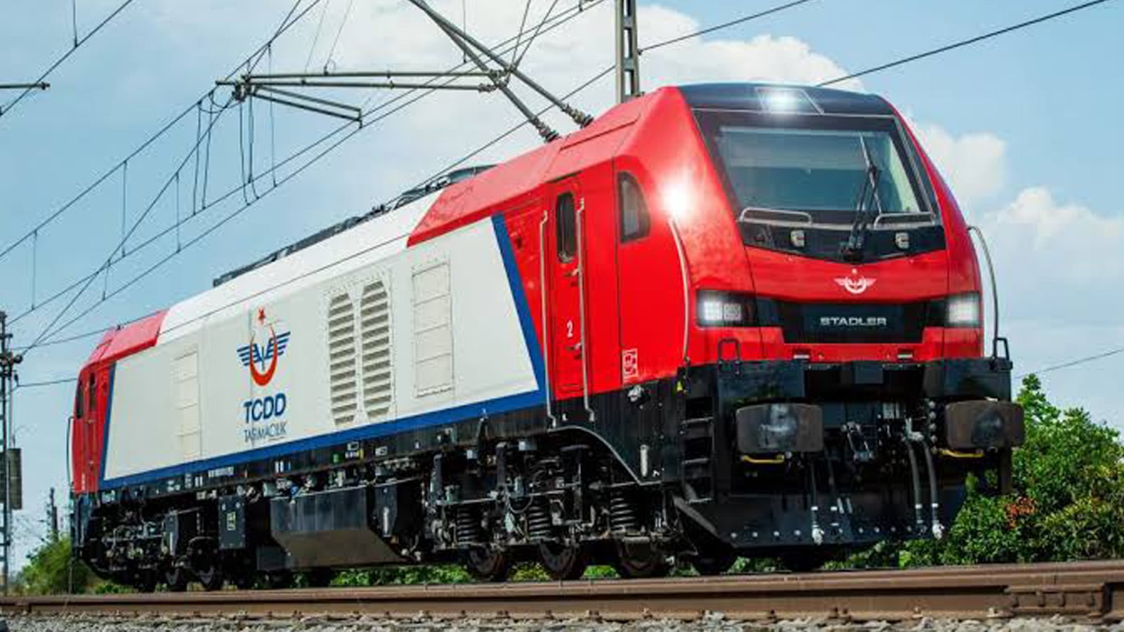 A modern red and white TCDD Taşımacılık locomotive in Turkey, representing the complex rail networks where ROMAN NG is deployed to improve capacity planning.